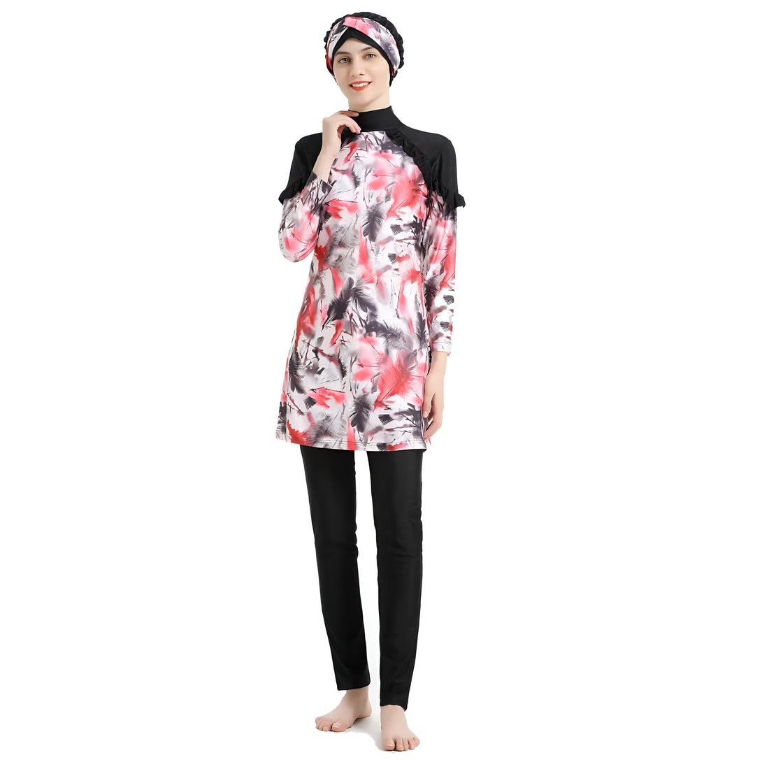 Une femme portant un maillot de bain musulman à manches longues avec un motif rouge et noir et un foulard noir.