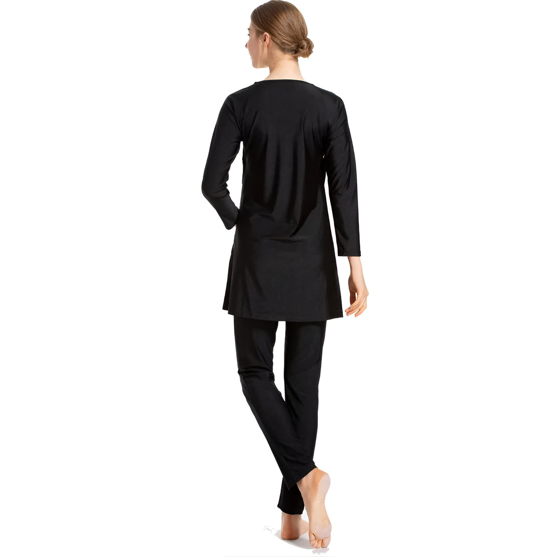 Une femme portant un maillot de bain musulman noir, avec une tunique et un pantalon longs.