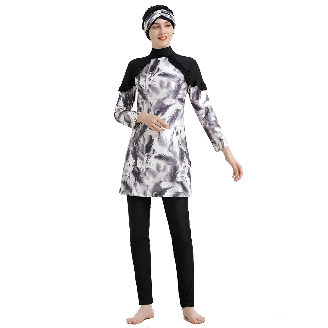 Une femme portant un maillot de bain musulman à manches longues avec un motif de plumes grises et blanches et un hijab noir.