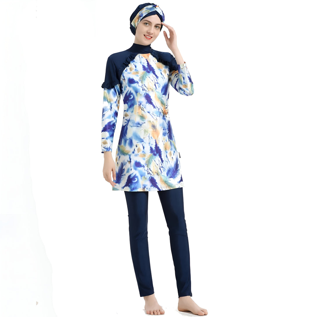 Une femme portant un maillot de bain musulman bleu avec un motif de plumes. Elle porte un hijab assorti.