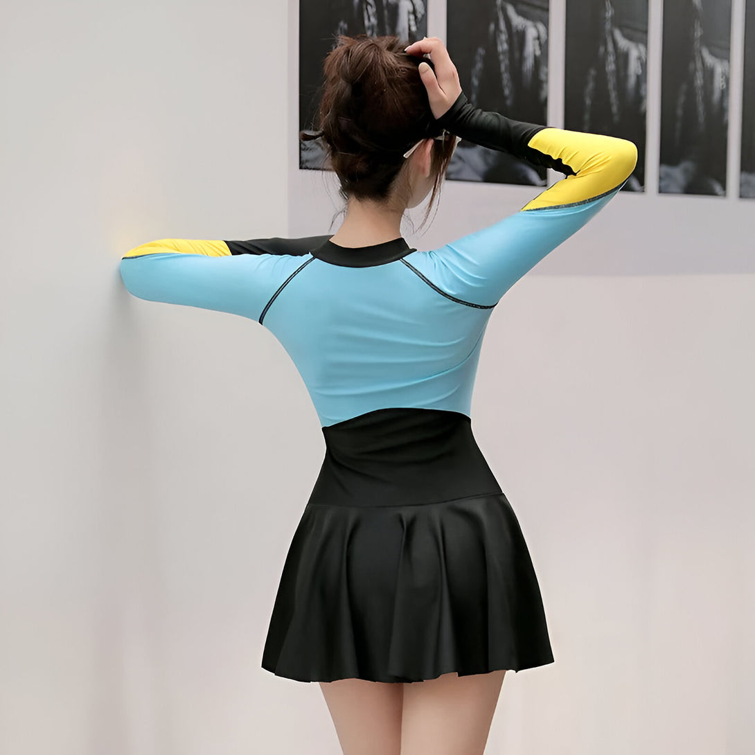 Une femme portant une robe de bain musulmane bleue et noire avec une jupe plissée. La robe de bain a des manches longues et est conçue pour la natation et les sports nautiques.