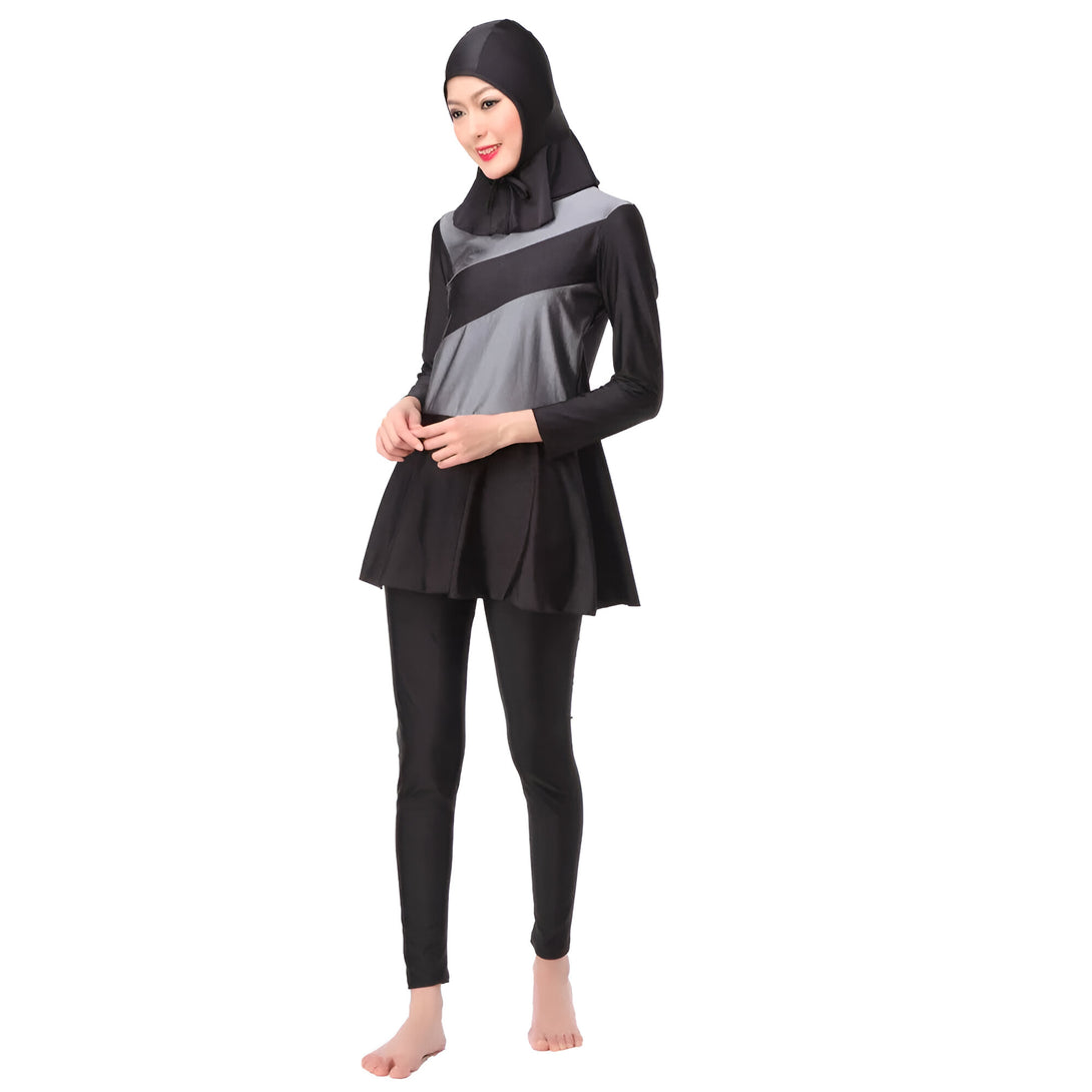 Une femme portant un maillot de bain musulman noir et gris avec un hijab assorti.