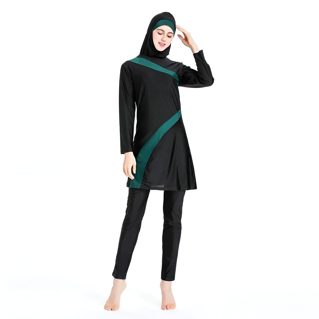 Une femme porte un maillot de bain musulman noir avec des accents verts. Le maillot de bain est conçu pour couvrir tout le corps, à l'exception du visage, des mains et des pieds. Il est parfait pour la natation et les activités nautiques.