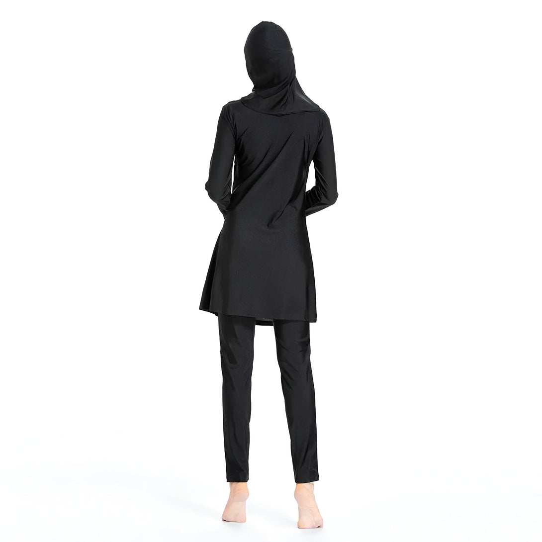 Une femme portant un maillot de bain musulman noir, avec un hijab assorti, vue de dos.