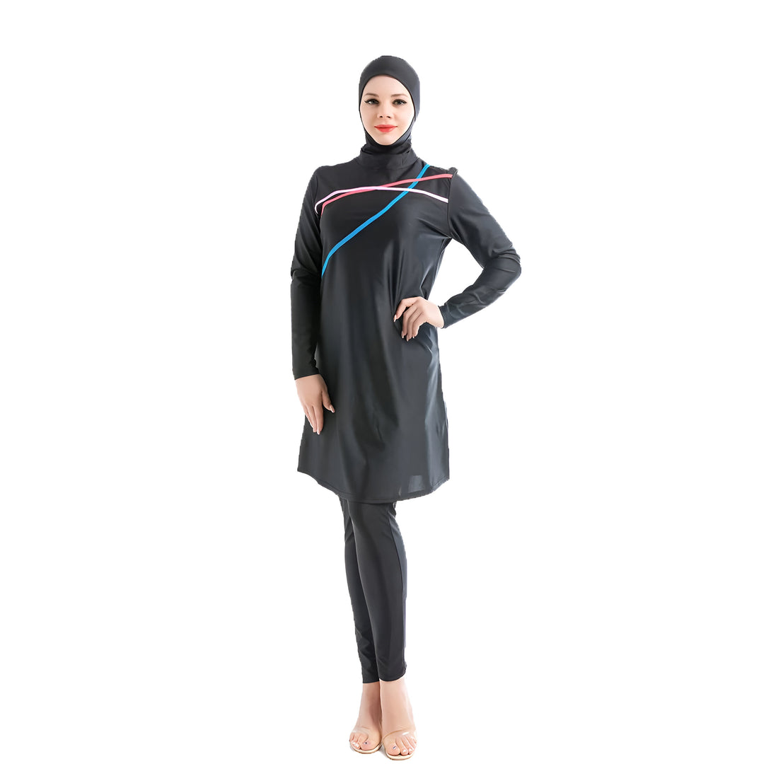 Une femme portant un maillot de bain musulman noir avec des détails colorés. Le maillot de bain a des manches longues et couvre tout le corps. La femme porte un hijab assorti et sourit à la caméra.