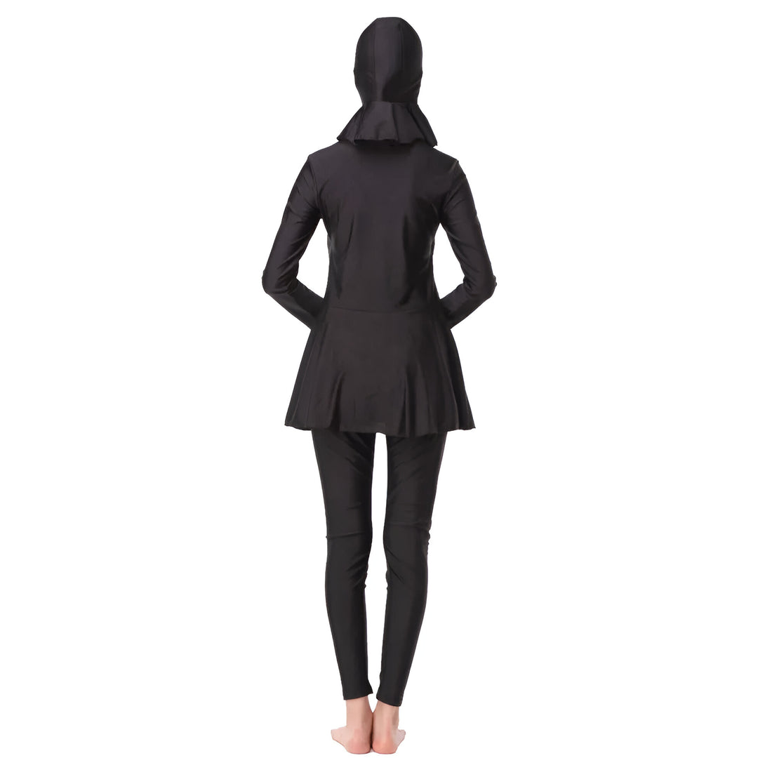 Une femme portant un burkini noir, de dos, sur fond blanc.