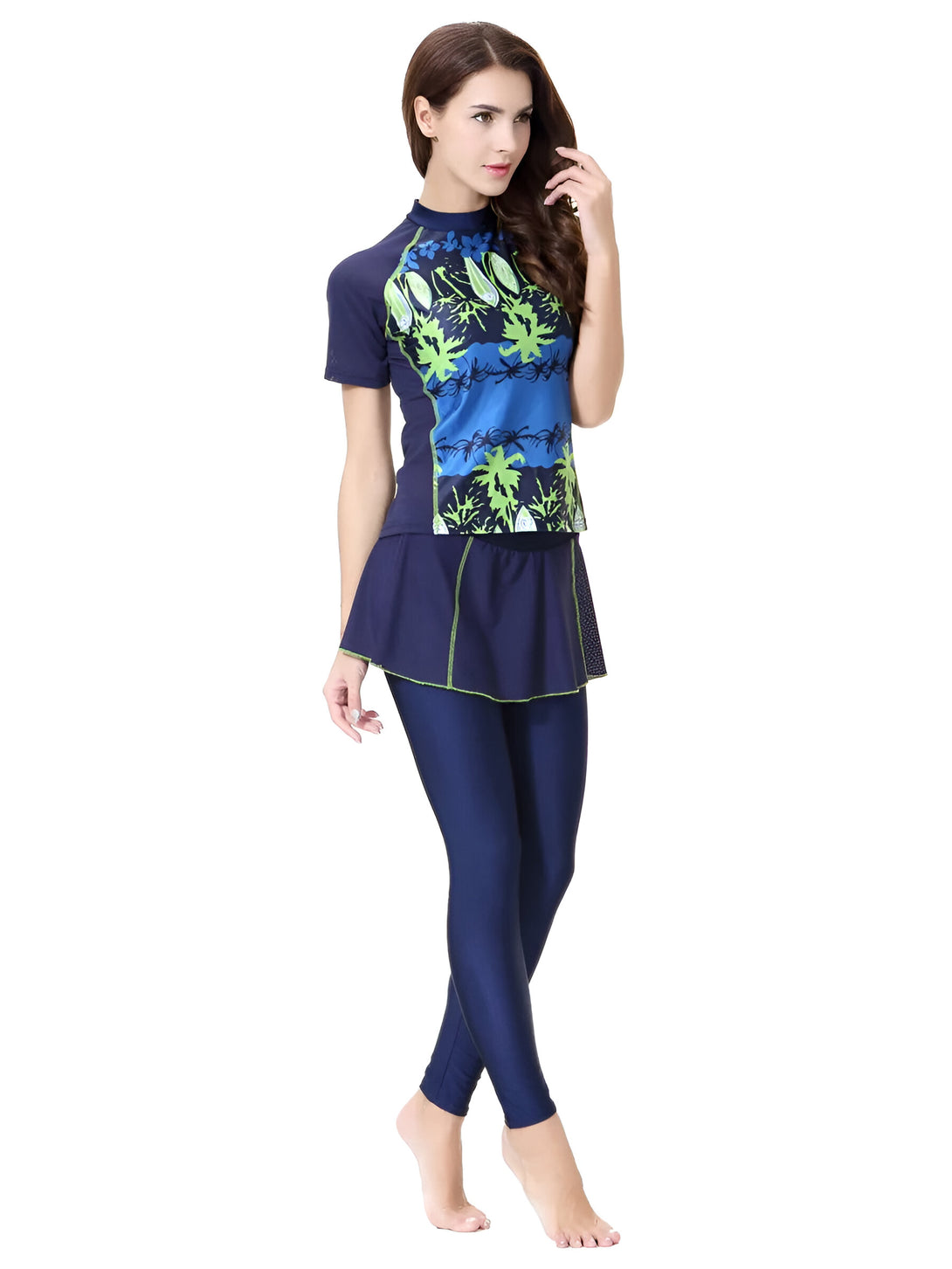 Une femme portant un maillot de bain musulman bleu avec des motifs verts. Le maillot de bain comprend un haut à manches courtes, une jupe et un pantalon.