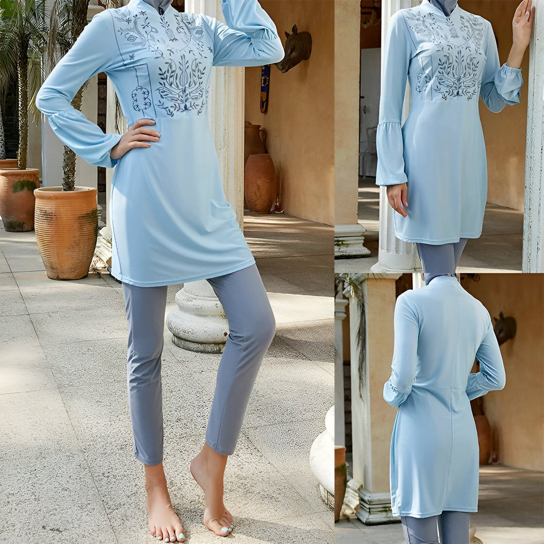 Une femme porte un maillot de bain musulman bleu clair avec une broderie florale. Le maillot de bain est à manches longues et a des jambes longues.