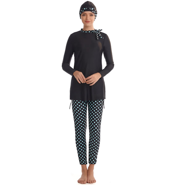 Une femme portant un maillot de bain musulman noir avec des leggings à motifs turquoise et noirs. Le maillot de bain comprend une tunique à manches longues et un foulard assorti.