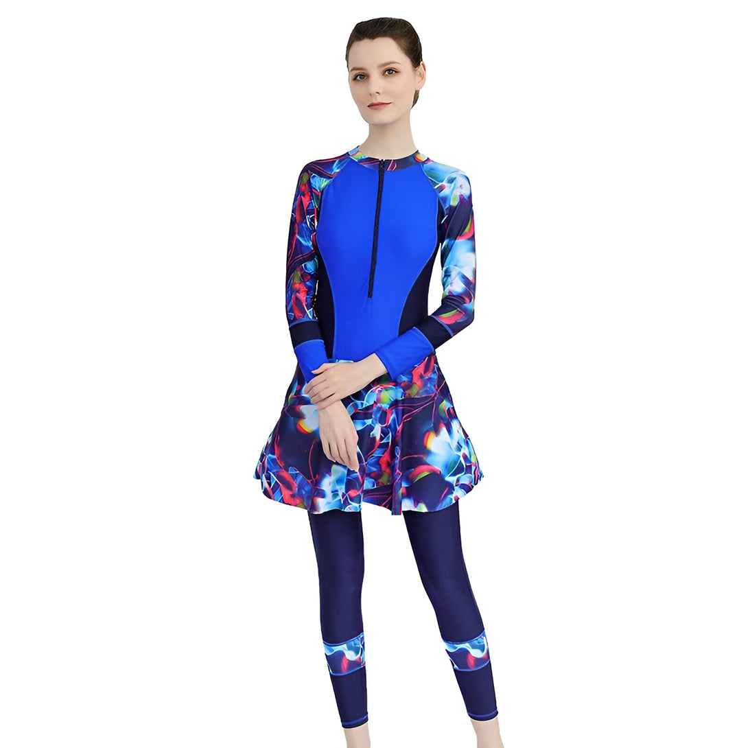 Une femme portant un maillot de bain musulman bleu et noir avec un motif floral. Le maillot de bain a des manches longues et une jupe.