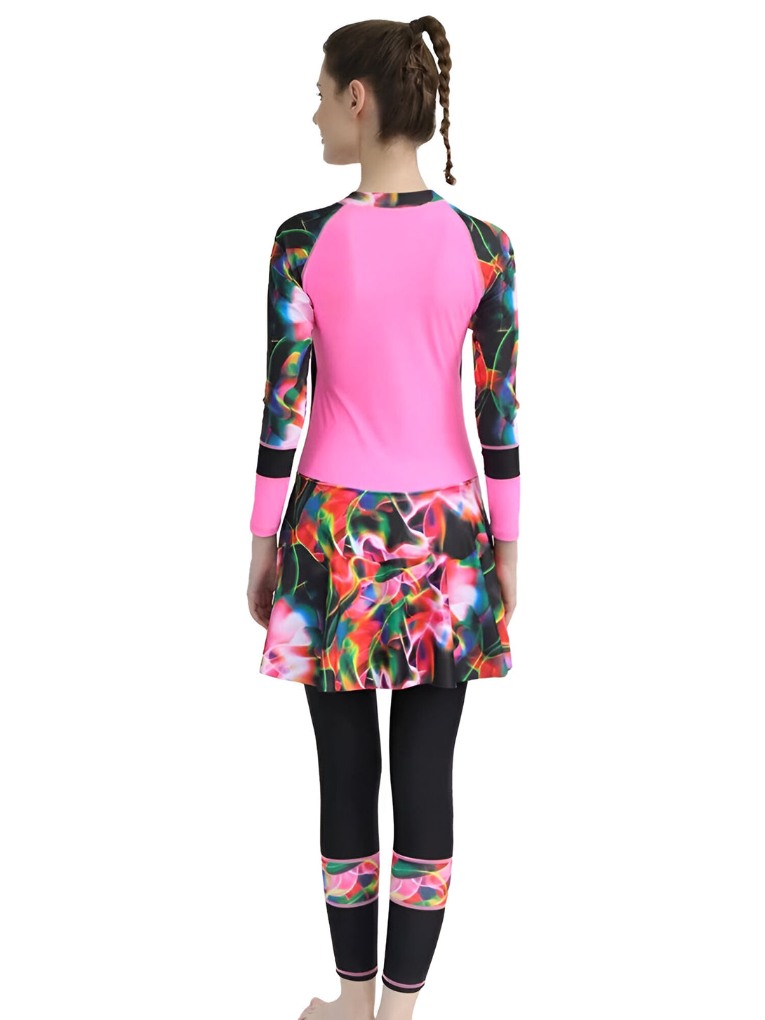 Une femme porte un maillot de bain musulman rose avec une jupe à imprimé floral coloré et un pantalon noir.