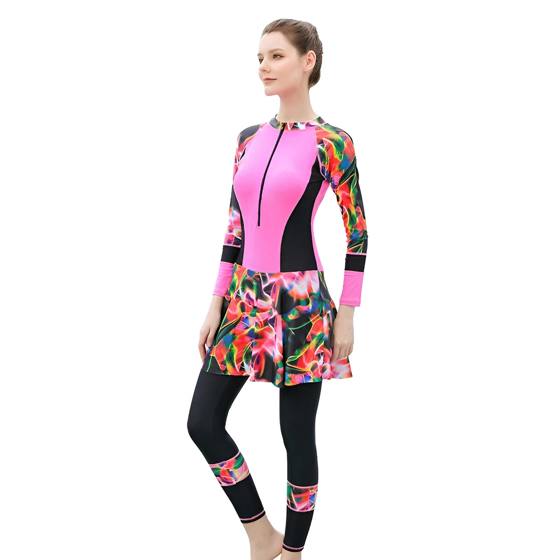 Une femme portant une burkini rose à manches longues avec un motif floral sur la jupe. Le burkini est idéal pour la natation et les sports nautiques tout en respectant les traditions islamiques.
