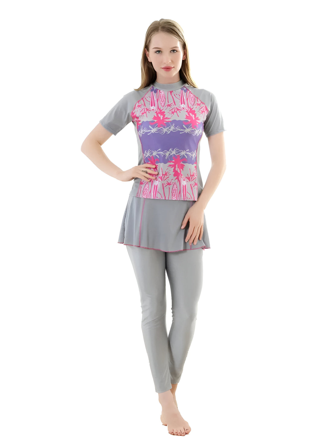 Une femme porte un maillot de bain musulman gris à manches courtes avec un motif floral rose et violet. Le maillot de bain est composé d'un haut et d'un pantalon.