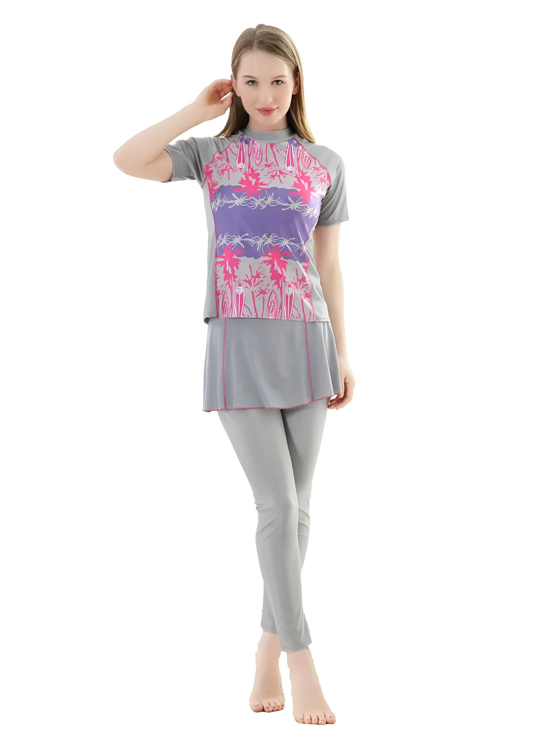 Une femme porte un maillot de bain musulman gris avec un motif rose et violet de palmiers. Le maillot de bain comprend un haut à manches courtes, une jupe et un pantalon.