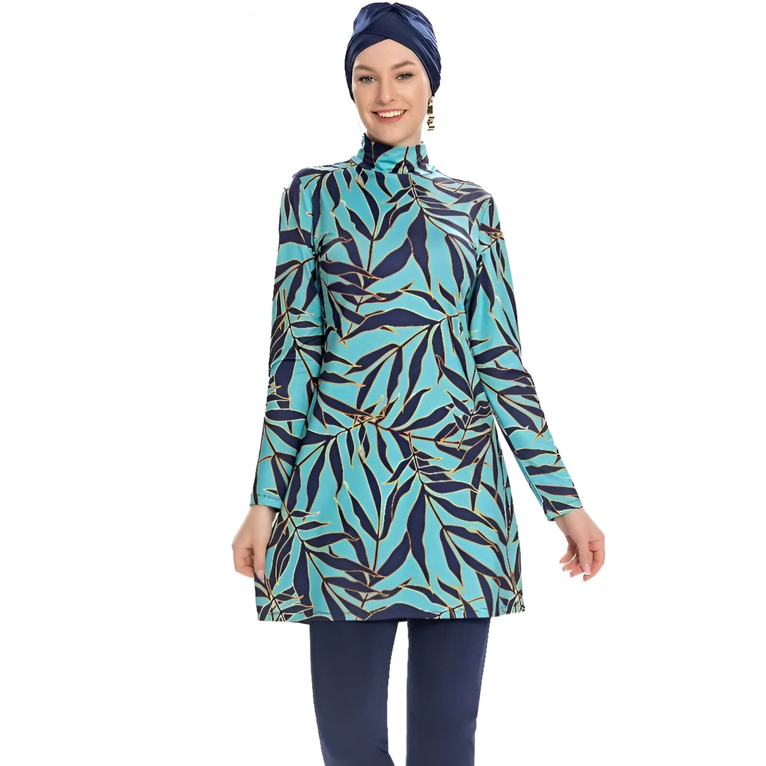 Une femme portant un hijab bleu marine et un maillot de bain musulman turquoise à motifs de feuilles.