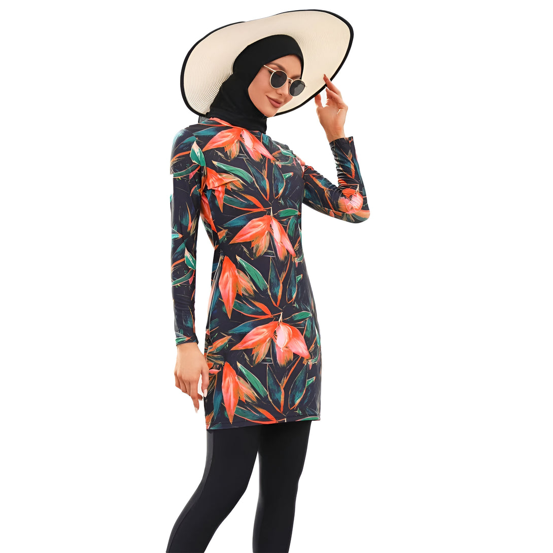 Une femme portant un maillot de bain musulman à manches longues avec un imprimé floral et un chapeau de paille.  Elle porte des lunettes de soleil.