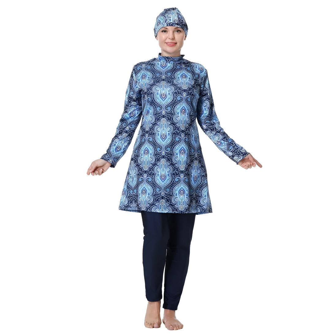 Une femme portant un maillot de bain musulman bleu avec un motif floral. La tenue est à manches longues et comprend un pantalon long.