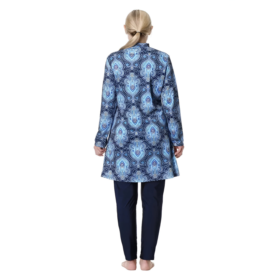 Une femme portant un maillot de bain musulman bleu à motifs. Le maillot de bain est à manches longues et comprend un pantalon long.