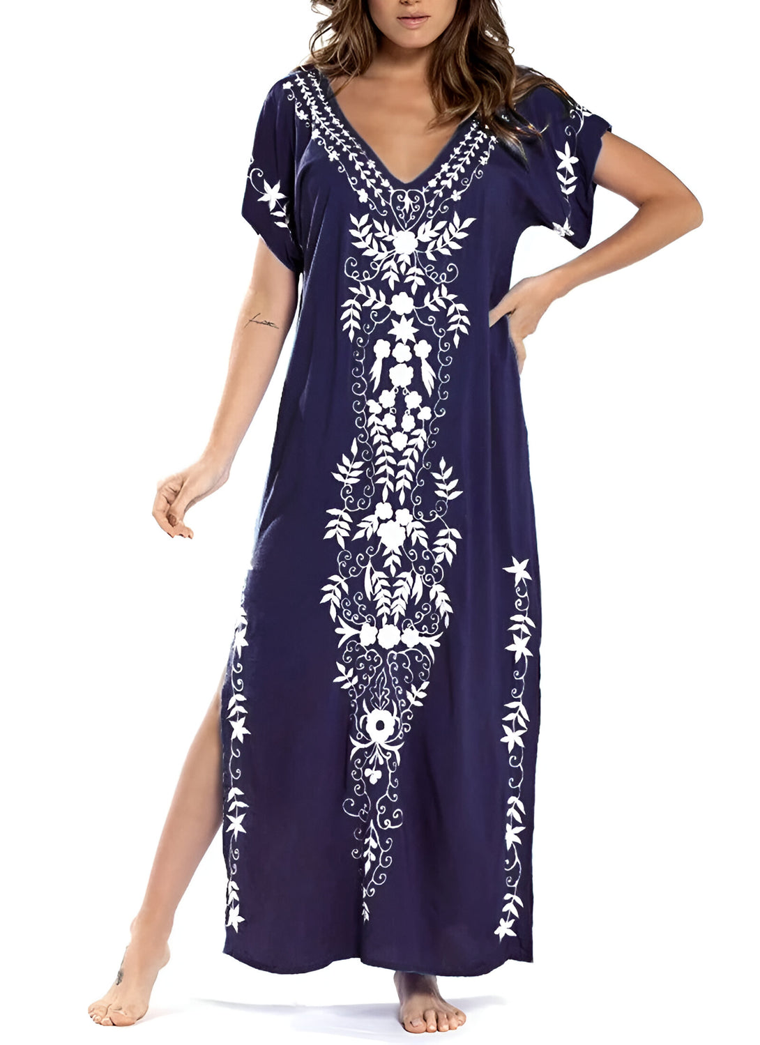 Une femme porte une longue robe bleu marine avec des motifs blancs brodés. La robe a un col en V et des manches courtes. Elle est parfaite pour les occasions spéciales ou pour un look décontracté et élégant.