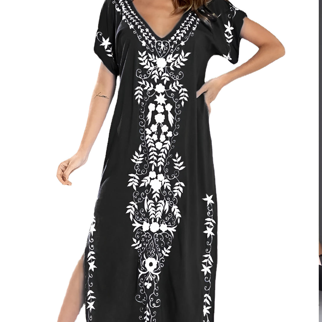 Robe longue noire en coton avec un motif floral blanc brodé. La robe est à manches courtes et a un col en V.  Parfait pour une occasion spéciale ou pour un look décontracté.
