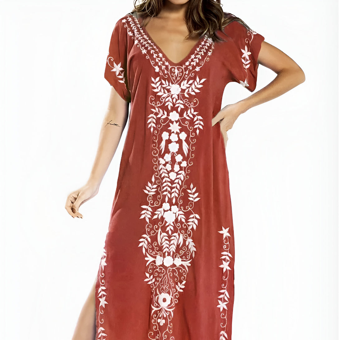 Robe longue ample de couleur rouille avec des broderies blanches de fleurs et de feuilles.  Parfait pour un look élégant et décontracté.