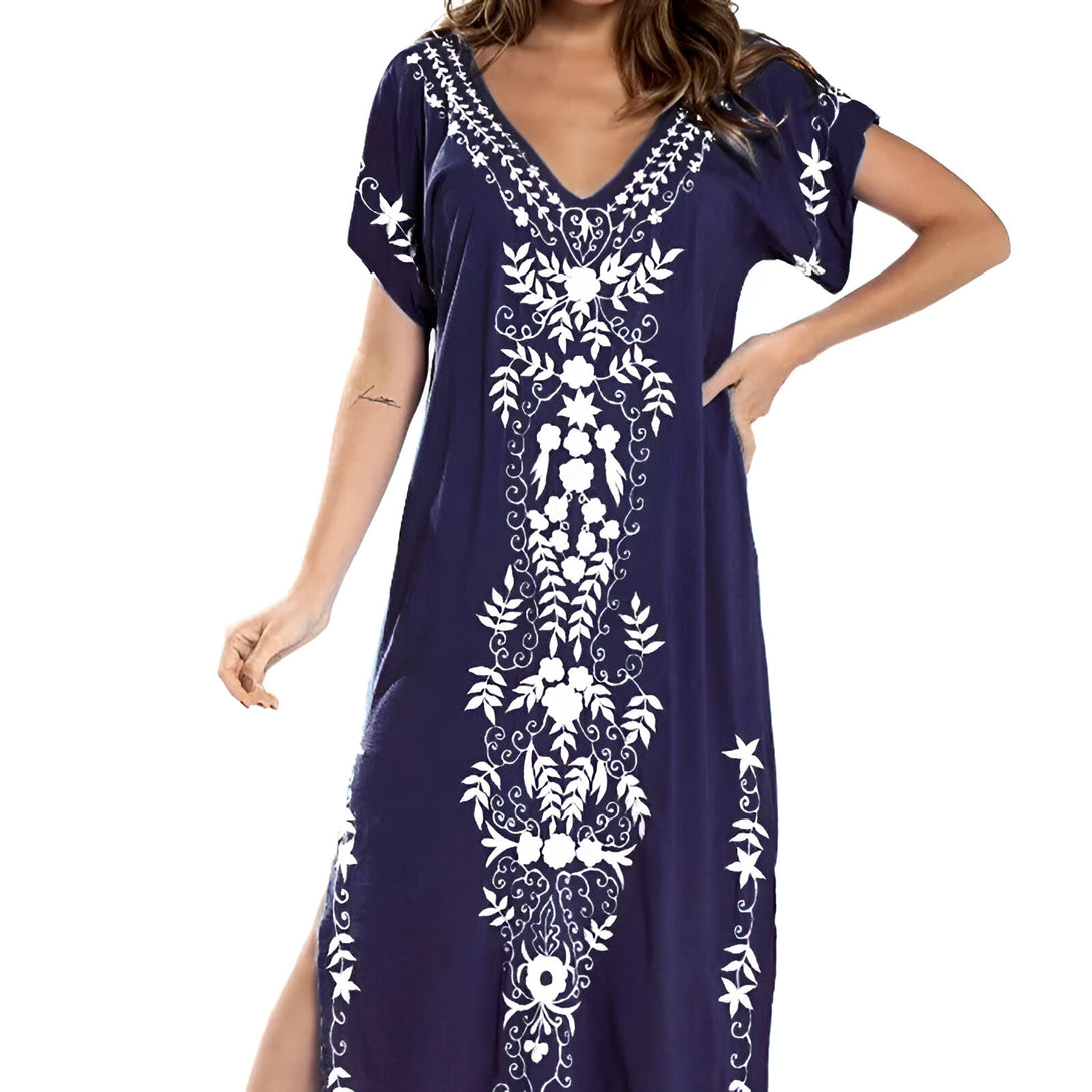 Robe longue bleu marine avec des broderies blanches de fleurs et de feuilles. La robe a un décolleté en V et des manches courtes. Elle est parfaite pour les occasions spéciales.
