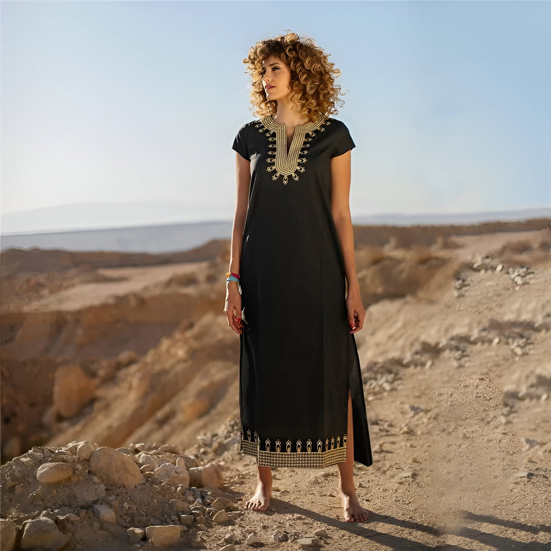 Une femme portant une longue robe noire élégante avec des détails dorés, idéale pour un look musulman chic.