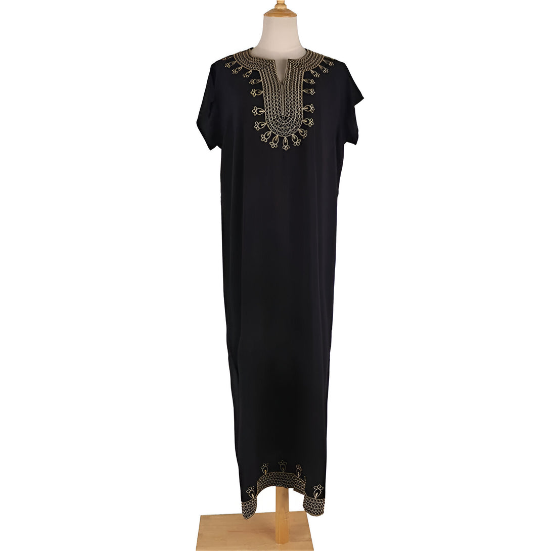 Robe longue noire pour femme avec des broderies dorées sur le col et le bas. La robe est présentée sur un mannequin en bois.