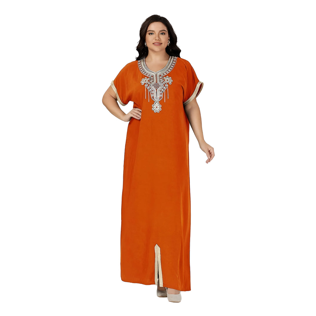 Une femme porte une robe longue orange avec des détails brodés dorés. La robe a des manches courtes et une fente au bas.
