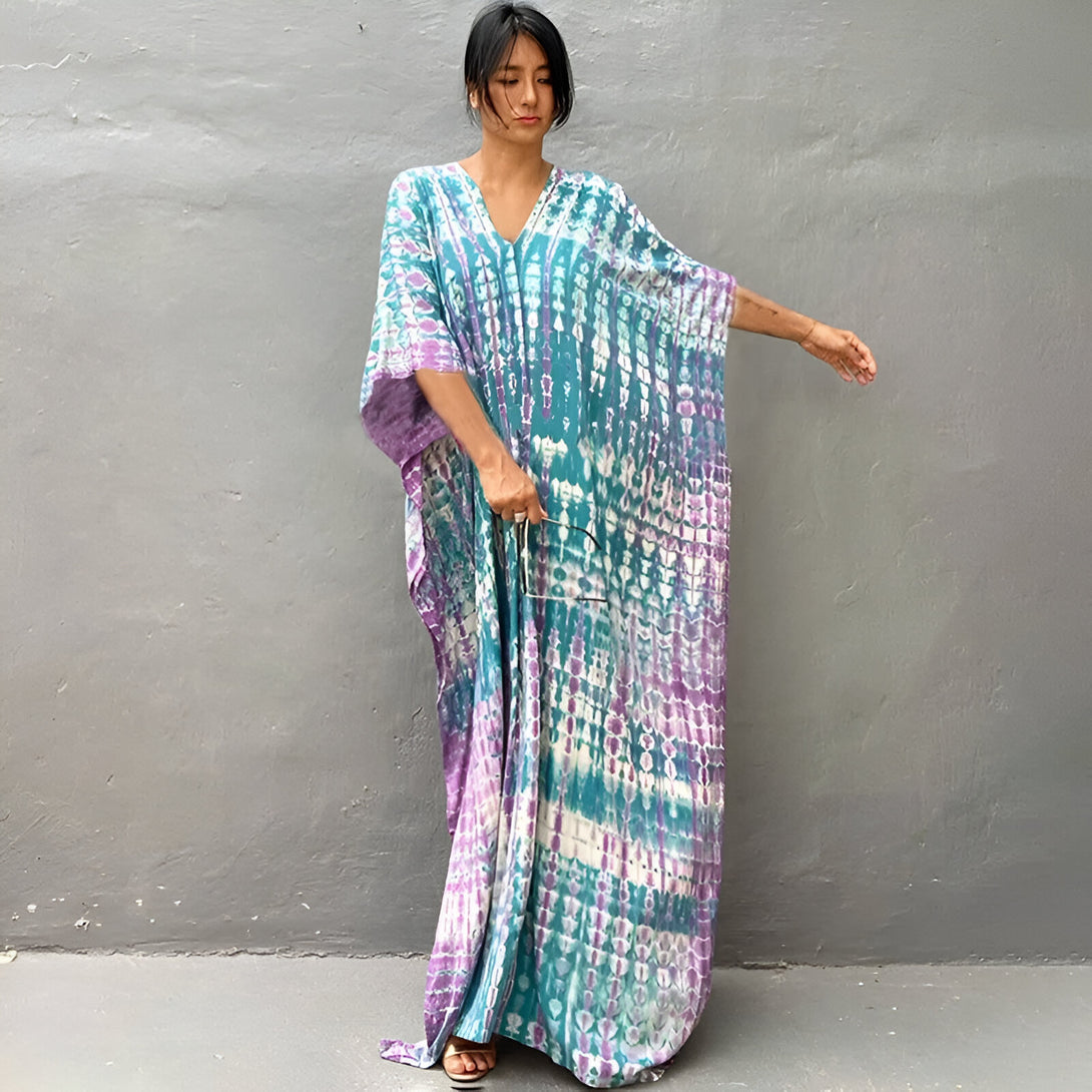 Une femme portant une longue robe de style musulman en tissu tie-dye bleu et violet.