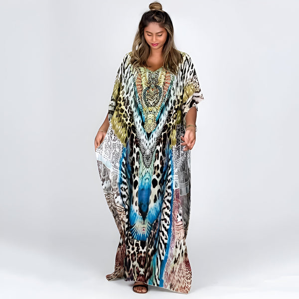 Une femme portant une longue robe de plage à imprimé léopard et bleu avec des détails dorés. La robe est ample et fluide, idéale pour les occasions décontractées et les vacances.