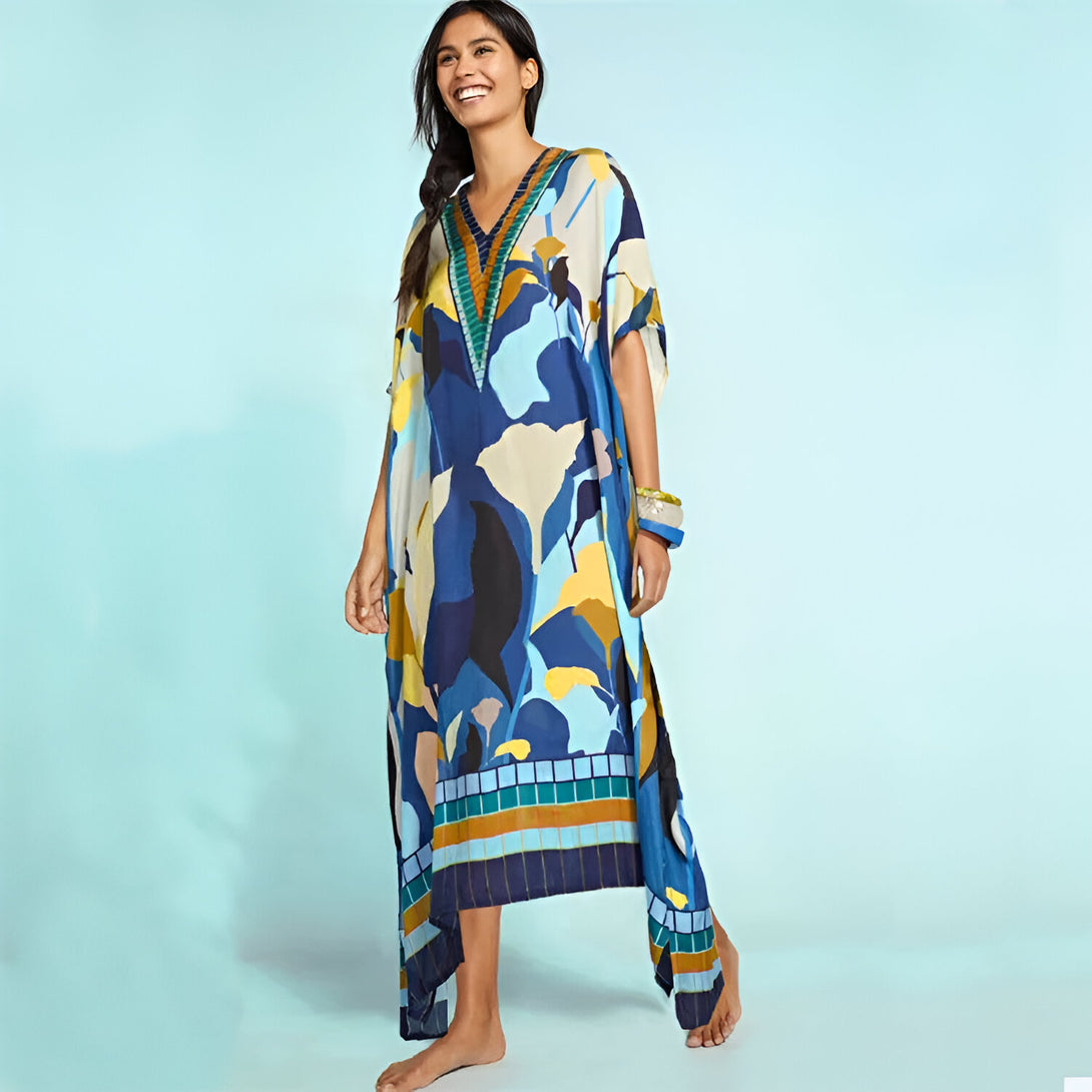 Une femme porte une longue robe bleue et blanche à fleurs. La robe est ample et élégante, parfaite pour un look décontracté et chic. La robe est disponible dans une variété de couleurs et de motifs.
