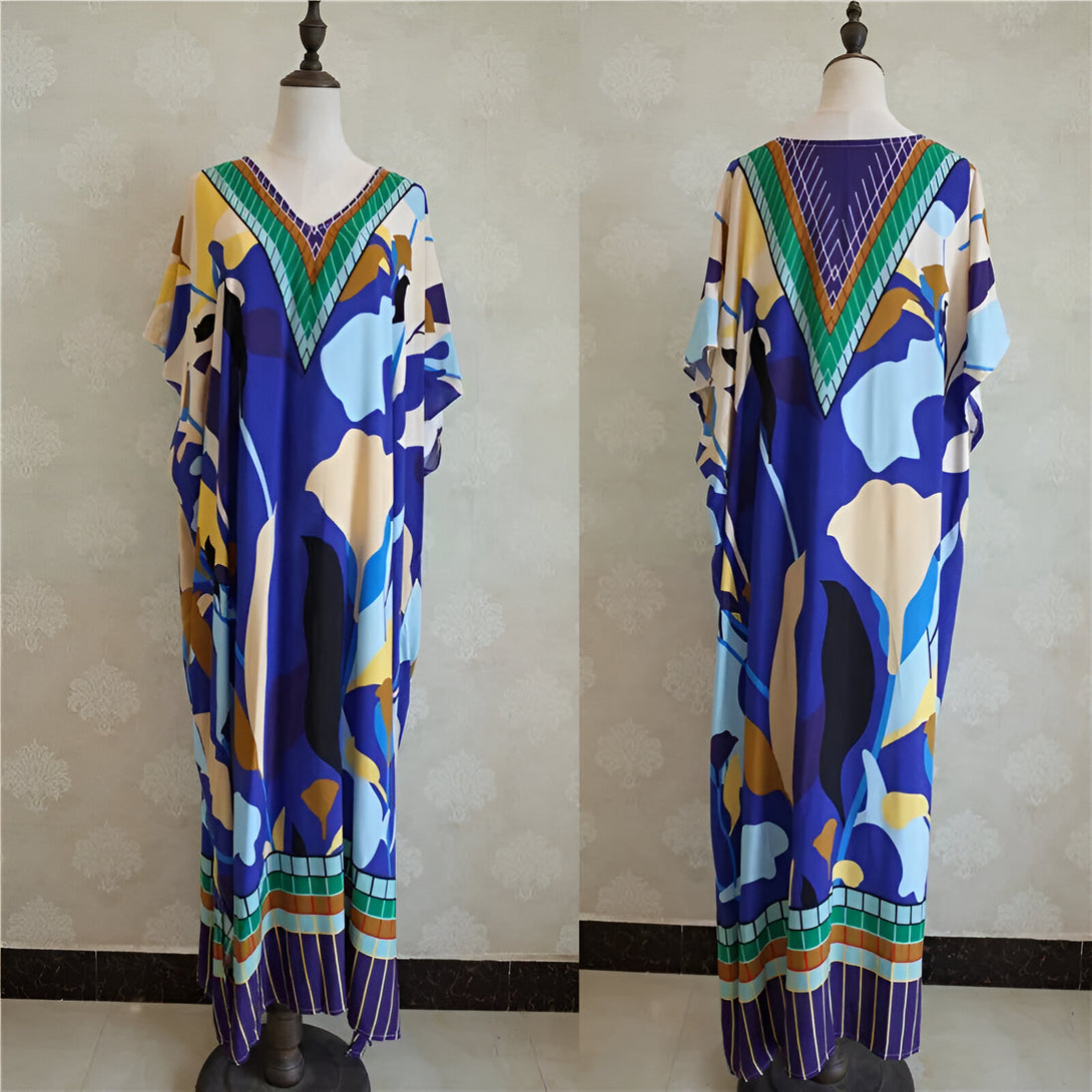 Robe longue musulmane à manches courtes, avec un motif floral bleu, beige et vert. Elle est parfaite pour les occasions spéciales.