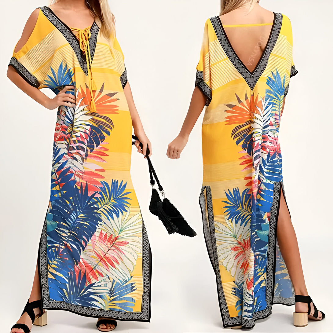 Robe longue musulmane jaune avec un imprimé tropical de feuilles bleues, rouges et blanches. La robe a des manches courtes et une encolure en V. Elle est parfaite pour l'été.