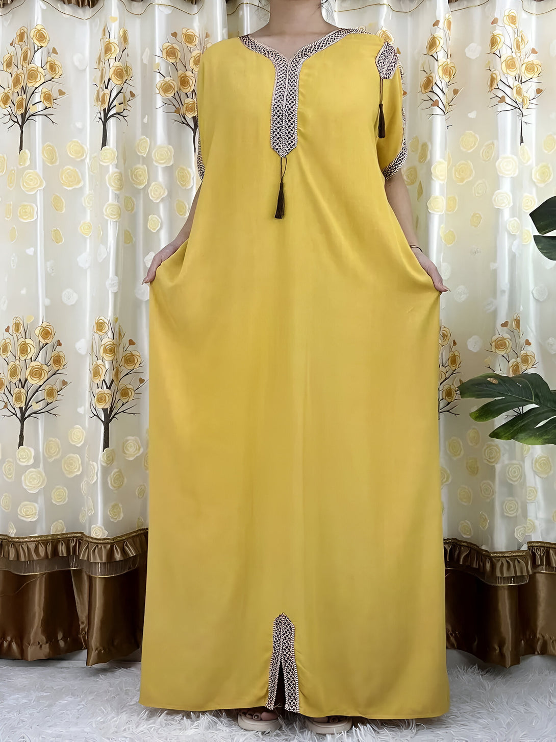 Robe longue jaune musulmane avec des broderies et des glands, idéale pour les occasions spéciales.