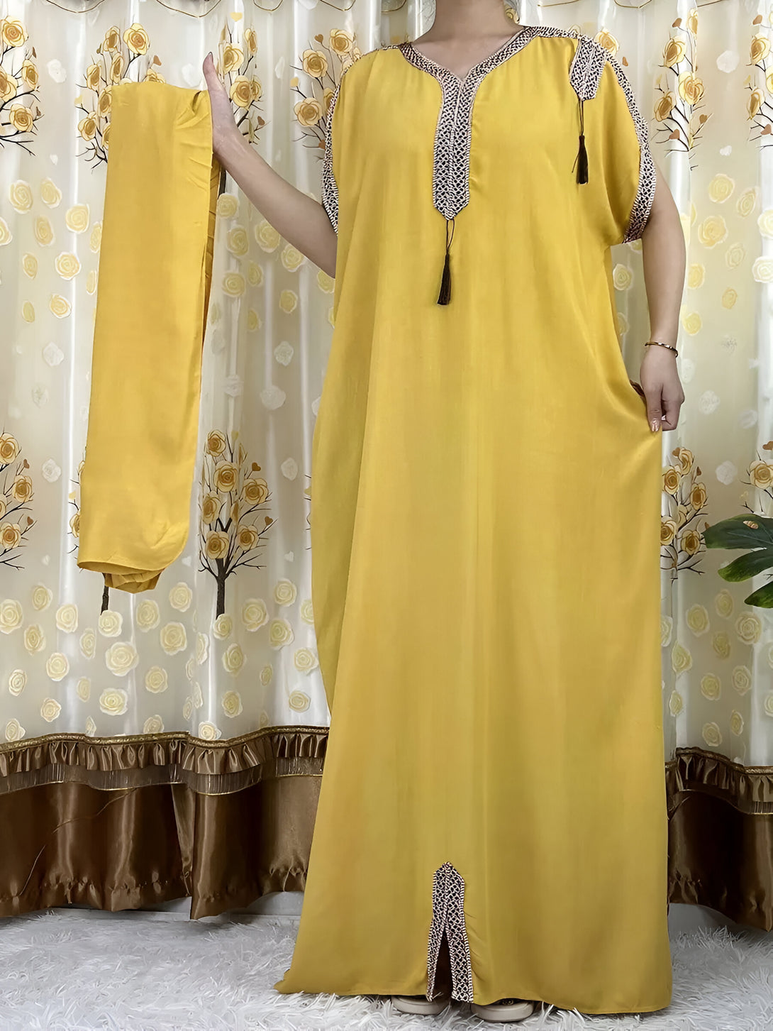 Une robe longue jaune avec des manches courtes et un col en V, ornée de détails brodés. La robe est accompagnée d'un hijab assorti.  Parfait pour les occasions spéciales ou pour un look décontracté chic.