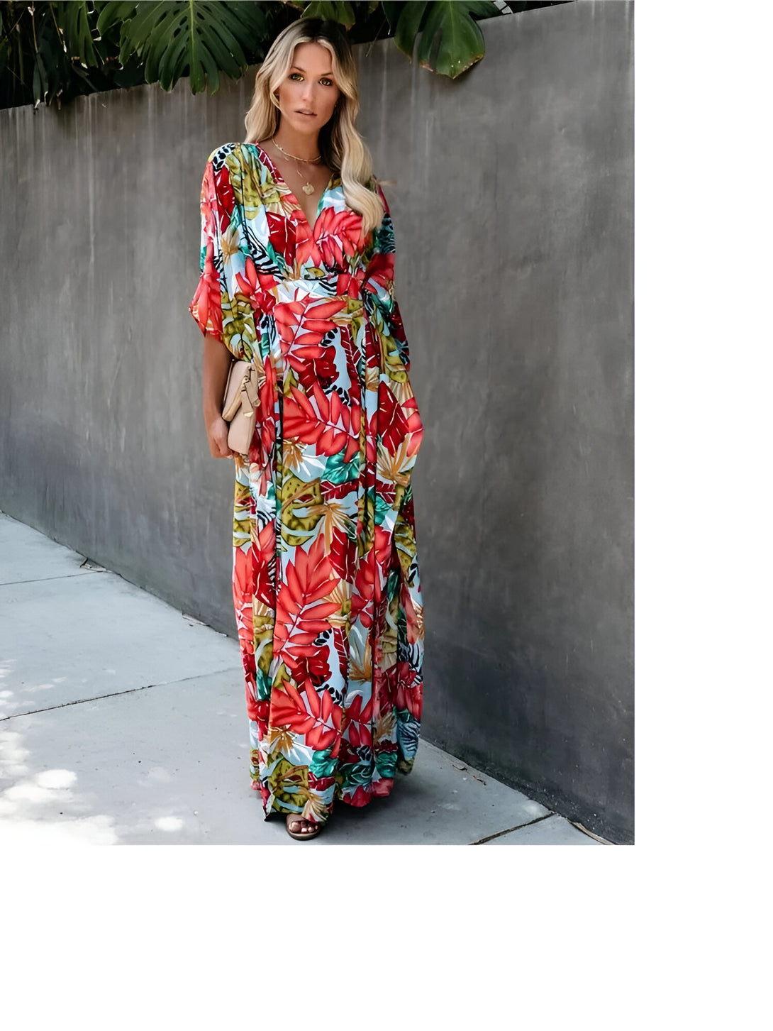 Une femme portant une longue robe musulmane à manches longues avec un imprimé floral coloré. La robe est ample et élégante, parfaite pour les occasions spéciales.
