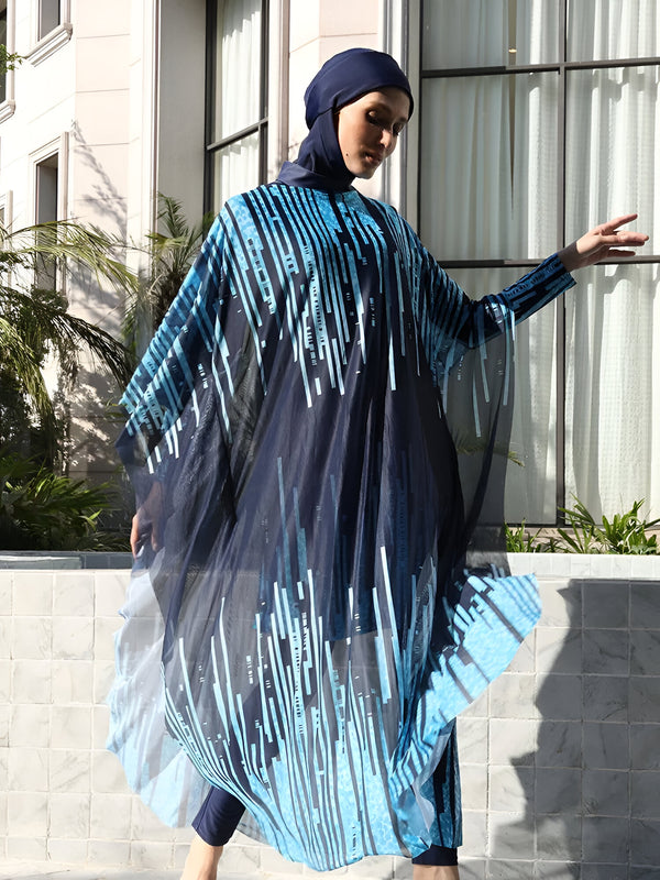 Une femme portant un hijab bleu marine et un maillot de bain musulman bleu marine avec un motif bleu clair. Le maillot de bain est à manches longues et a une jupe longue qui s'étend jusqu'aux chevilles.