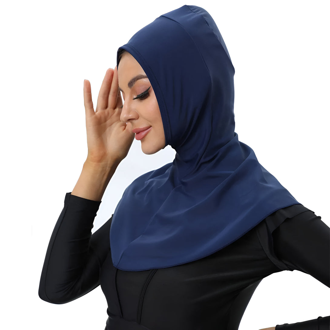 Une femme portant un hijab bleu marine, idéal pour la natation ou les sports nautiques.  Le hijab est fabriqué dans un tissu respirant et léger, parfait pour rester au frais et à l'aise.