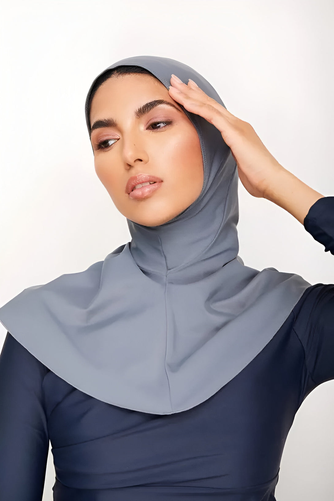 Une femme portant un hijab gris et un maillot de bain musulman bleu marine.