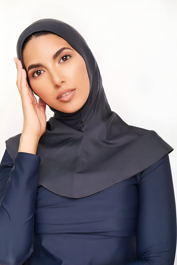 Une femme portant un hijab gris foncé et un maillot de bain bleu marine. La tenue est idéale pour la natation et les activités aquatiques.