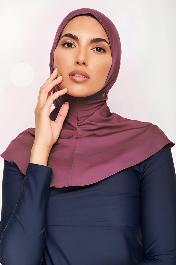 Une femme portant un hijab bordeaux et une robe de bain bleu marine. Elle porte un vêtement modeste pour la natation.