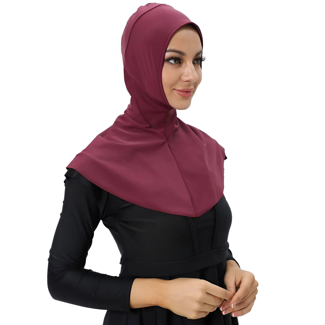 Une femme portant un hijab de couleur bordeaux et une robe de bain noire.