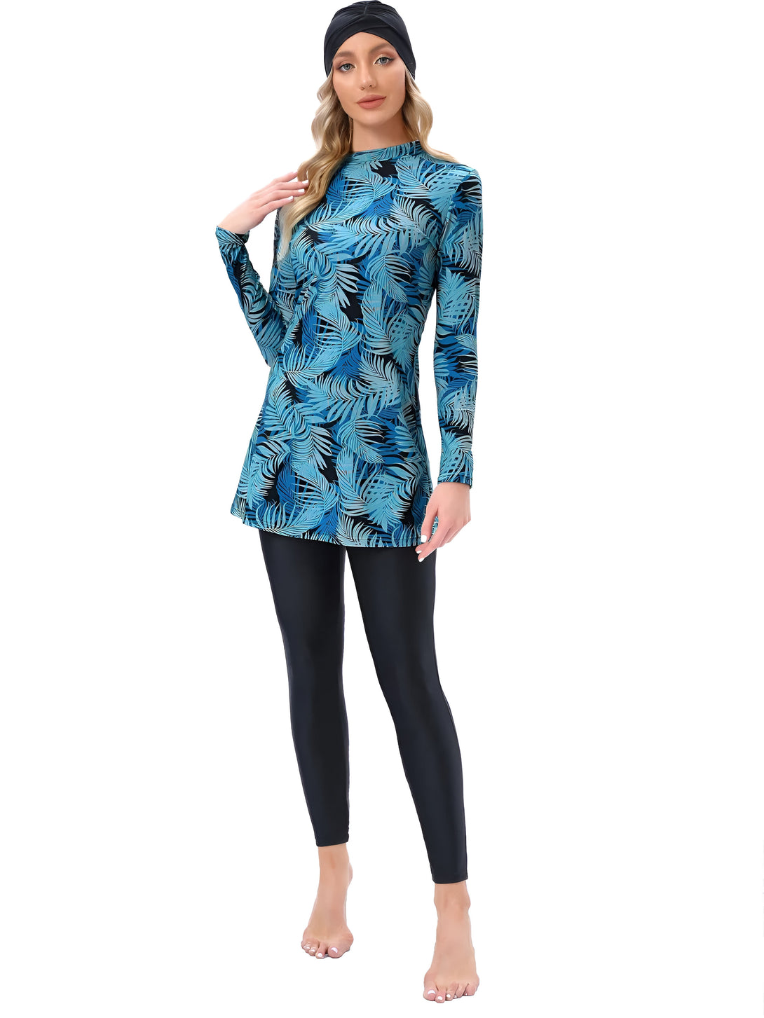 Une femme portant un maillot de bain musulman bleu avec un motif de feuilles tropicales et un hijab noir.