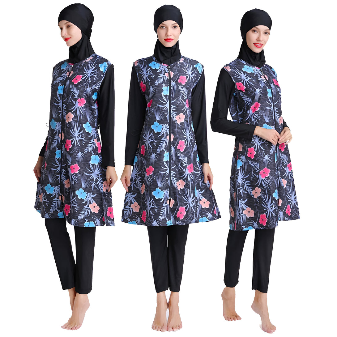 Trois femmes portant des maillots de bain islamiques à fleurs. Les maillots de bain sont noirs avec des fleurs bleues, roses et blanches. Les femmes portent également des hijabs noirs.
