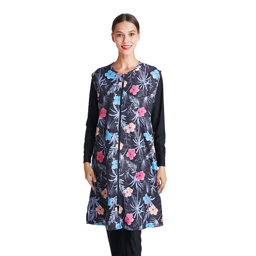 Une femme portant un maillot de bain musulman noir à manches longues avec un motif floral bleu, rose et corail.