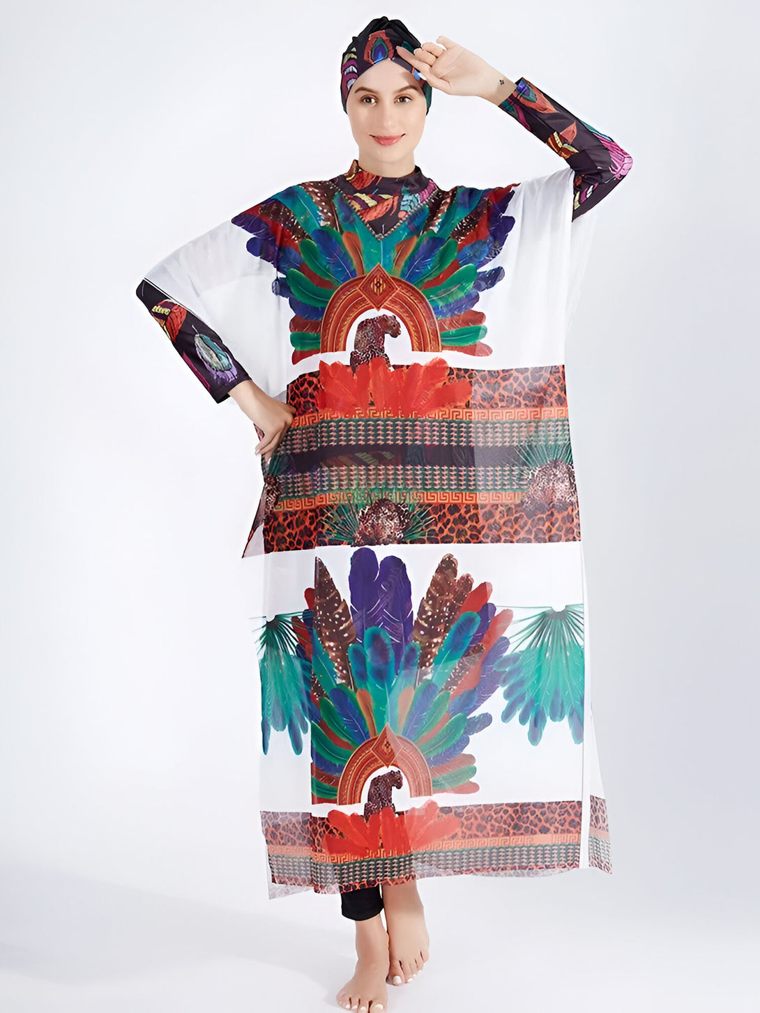 Une femme portant un hijab noir et une robe longue blanche à manches longues avec un motif de plumes colorées et léopard.