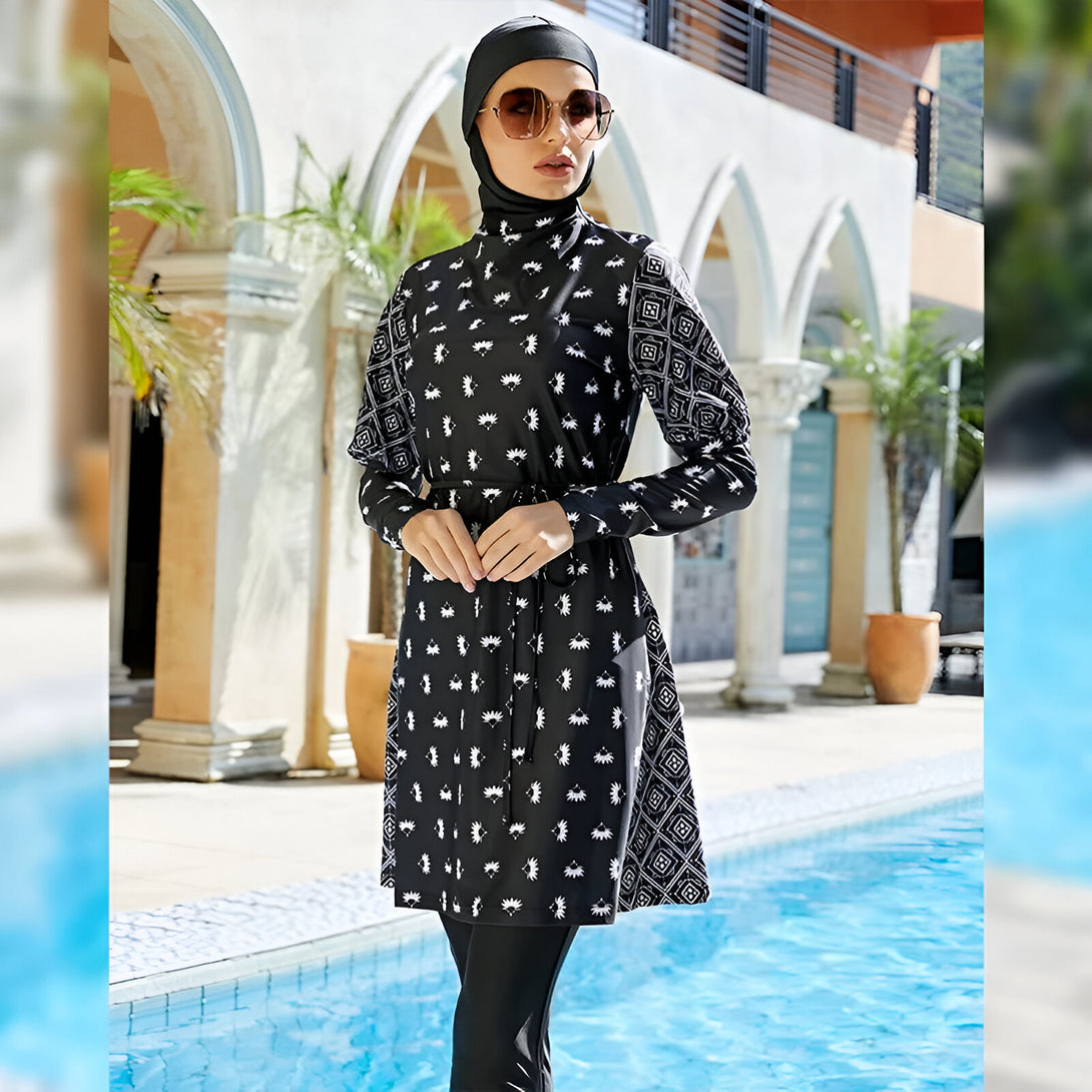 Une femme portant un maillot de bain musulman noir et blanc à motifs géométriques, près d'une piscine.