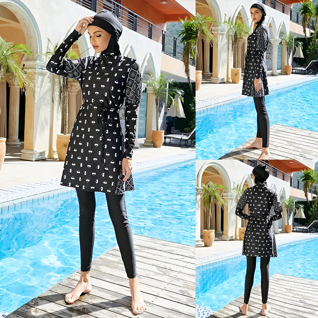 Une femme portant un maillot de bain musulman noir et blanc à motifs géométriques près d'une piscine. Elle porte un hijab noir et un pantalon long.