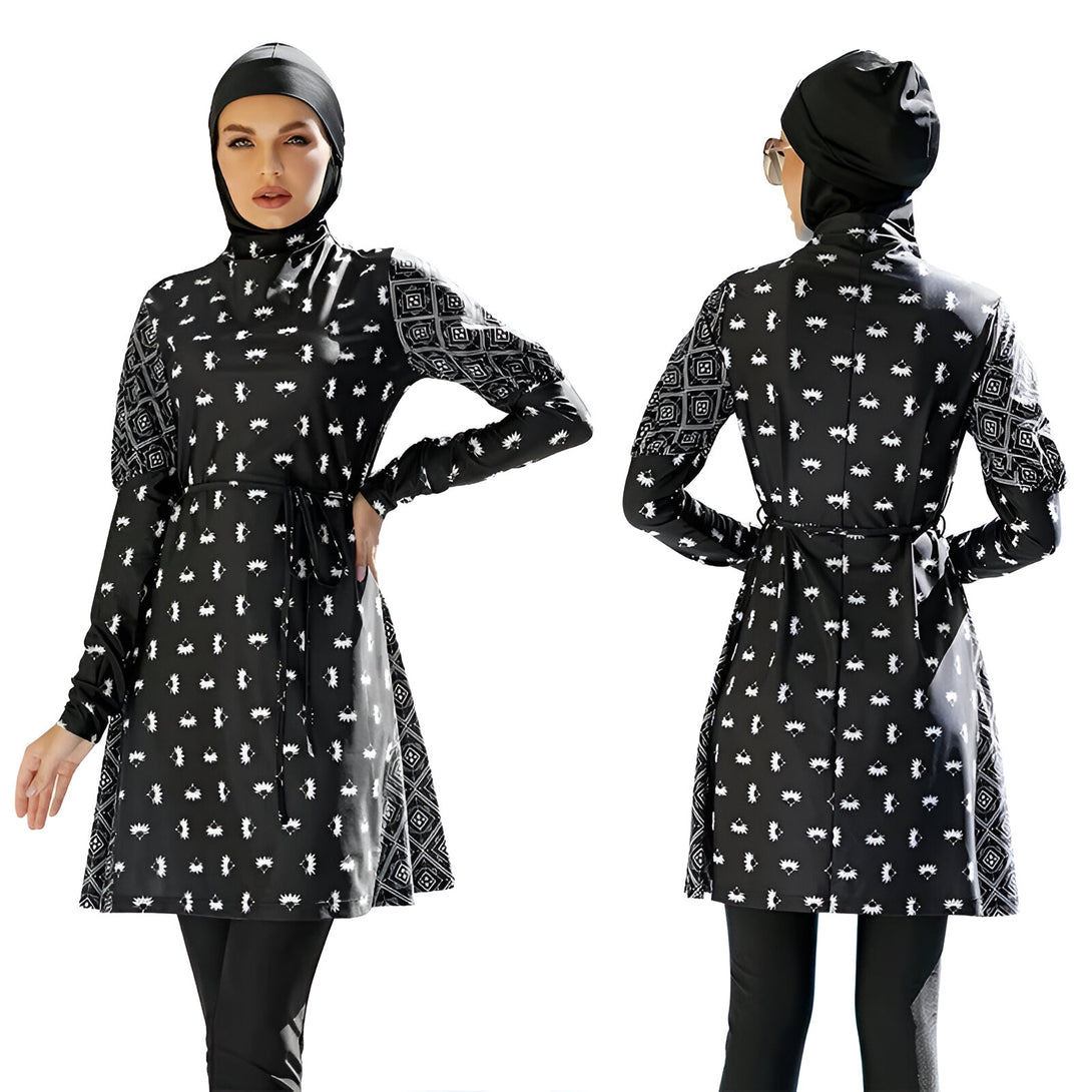 Une femme portant un maillot de bain musulman noir et blanc à manches longues avec une ceinture. Le maillot de bain est imprimé avec un motif géométrique.